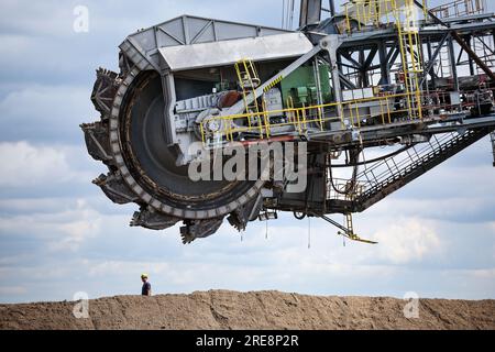 26. Juli 2023, Sachsen, Groitzsch: Ein Schaufelbagger „SRS 1300“ überquert die Bundesautobahn 176 auf dem Weg vom Tagebau Schleenhain zum ca. 10 km entfernten Bergbaufeld Peres. Die Maschine, die gut 1680 Tonnen wiegt, bewegt sich und wird ab dem Herbst weiterhin für den Braunkohlebergbau eingesetzt. Nach Angaben der Mitteldeutschen Braunkohlengesellschaft (Mibrag) ist der Bagger seit Juli 12 in Bewegung und wird am nächsten Montag am Zielort ankommen. Zum Schutz der Straße wurde die Straße mit Planen, Klebebändern und einer Schicht Kiessandmischung abgedeckt Stockfoto