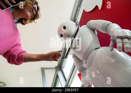 Eine Frau kommuniziert mit einem Roboterberater. Stockfoto