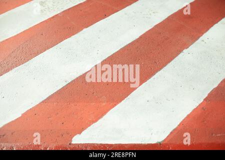 Plattform für Feuerlöschgeräte. Parkplätze für Feuerwehrleute. Asphalt wird in Streifen lackiert. Rot-weiße Streifen auf der Straße. Stockfoto