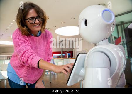 Eine Frau kommuniziert mit einem Roboterberater. Stockfoto
