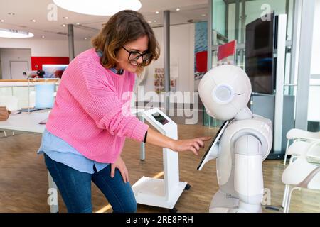 Eine Frau kommuniziert mit einem Roboterberater. Stockfoto