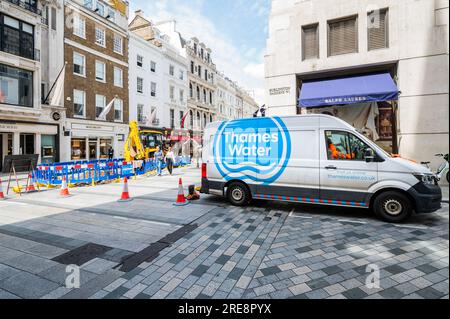 London, Großbritannien. 26. Juli 2023. Ein Arbeiter scheint im Van zu schlafen, vermutlich in einer Pause - wir reparieren Rohre, sagt das Schild am Zaun um ein Loch gegraben von Thames Water in der Old Bond Street. Der Mangel an Aktivität ist eine Metapher für die Probleme des Unternehmens und die langsamen Fortschritte bei der Behebung von Lecks. Kredit: Guy Bell/Alamy Live News Stockfoto