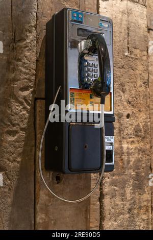 Nahaufnahme eines Münztelefons an der Holzwand. Stockfoto