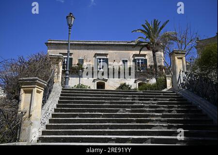 Malerischer Blick auf den barocken Palazzo Castro Polara Grimaldi, ein historisches Wahrzeichen von Modica aus der Scalinata di San Giorgio in Sizilien. Stockfoto