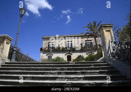 Malerischer Blick auf den barocken Palazzo Castro Polara Grimaldi, ein historisches Wahrzeichen von Modica aus der Scalinata di San Giorgio in Sizilien. Stockfoto