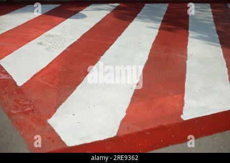 Plattform für Feuerlöschgeräte. Parkplätze für Feuerwehrleute. Asphalt wird in Streifen lackiert. Rot-weiße Streifen auf der Straße. Stockfoto