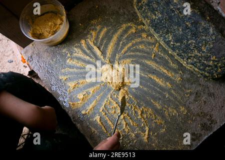 Zubereitung von peruanischem gelbem Chili, auch Aji-amarillo-Sauce genannt, mit einer vollen Mühle in der Stadt Cusco in Peru. Stockfoto