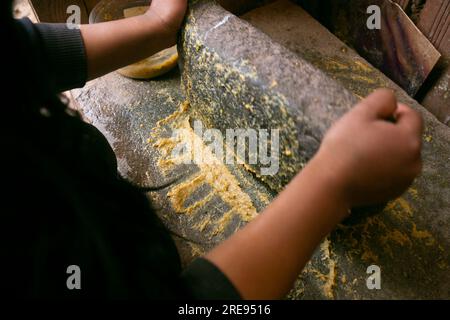 Zubereitung von peruanischem gelbem Chili, auch Aji-amarillo-Sauce genannt, mit einer vollen Mühle in der Stadt Cusco in Peru. Stockfoto