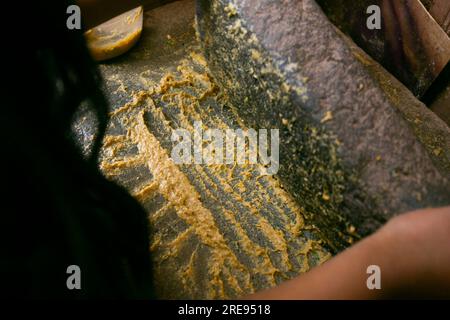 Zubereitung von peruanischem gelbem Chili, auch Aji-amarillo-Sauce genannt, mit einer vollen Mühle in der Stadt Cusco in Peru. Stockfoto