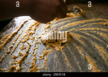 Zubereitung von peruanischem gelbem Chili, auch Aji-amarillo-Sauce genannt, mit einer vollen Mühle in der Stadt Cusco in Peru. Stockfoto