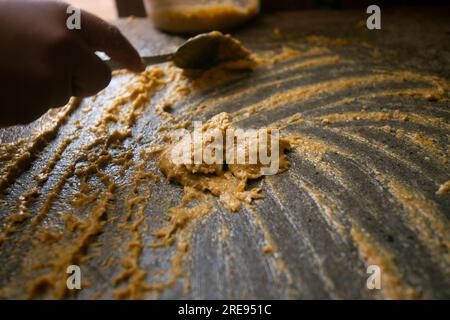 Zubereitung von peruanischem gelbem Chili, auch Aji-amarillo-Sauce genannt, mit einer vollen Mühle in der Stadt Cusco in Peru. Stockfoto