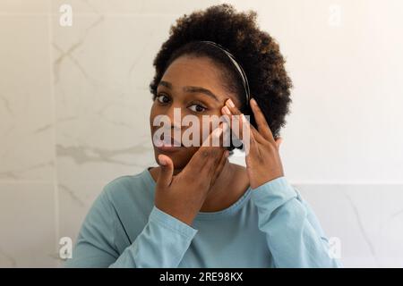 Porträt einer großen afroamerikanischen Frau im Badezimmer Stockfoto