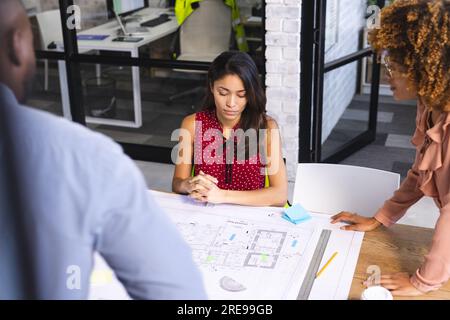 Fokussierte, vielfältige Kollegen diskutieren über das Projekt des Gebäudes im Büro Stockfoto