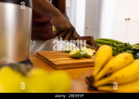 Mittelteil eines afroamerikanischen Mannes, der zu Hause in der Küche gesunden Smoothie zubereitet Stockfoto
