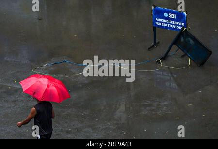 Imphal, Indien. 15. Juli 2023. Ein Mann hält einen Regenschirm, während er an einem bewölkten Tag in Thangal Bazar an einem SBI-Parkschild entlang der Straße vorbeigeht. SBI Life Insurance Company meldete für das Quartal zum Juni einen Nettogewinn von 381 Milliarden Rupien. Die Nettoprämieneinnahmen stiegen von Jahr zu Jahr um 19 % auf 13.104 Milliarden indische Rupien. (Foto: Biplov Bhuyan/SOPA Images/Sipa USA) Guthaben: SIPA USA/Alamy Live News Stockfoto