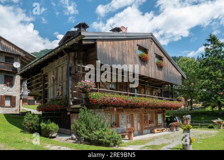 Sauris, Italien (20. Juli 2023) - Blick auf ein typisches Holzhaus im alpinen Dorf Sauris di sotto Stockfoto