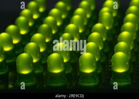 Nahaufnahme mehrerer leds durch Loch die grüne Farbe auf dem Tisch im abgedunkelten Raum Stockfoto