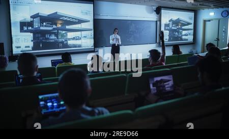 Junge Lehrerin, die eine Vorlesung zur Datenwissenschaft für verschiedene ethnische Gruppen von weiblichen und männlichen Schülern im Dark College Room hält. Diashow Wird Projiziert Stockfoto