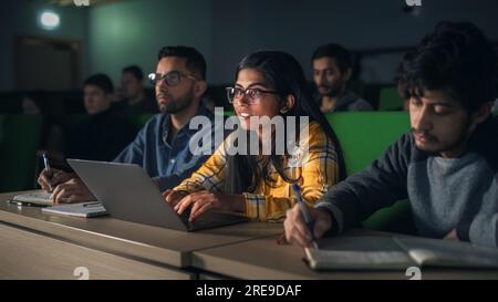Schlaue junge Studenten, die an der Universität mit verschiedenen multiethnischen Klassenkameraden studieren. Die Gelehrten unterhalten sich im College Room. Anwenden Von Wissen Stockfoto