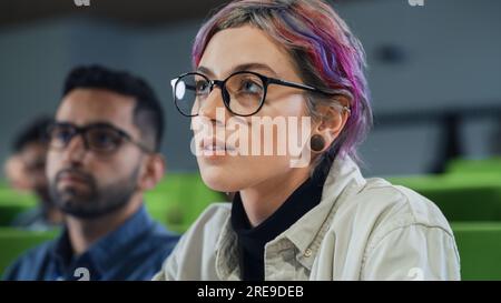 Nahaufnahme des Porträts eines kreativen Schülers in einer Vorlesung. Junge Person, die mit verschiedenen multiethnischen Klassenkameraden an der Universität studiert, nimmt an der Konferenz Teil Stockfoto