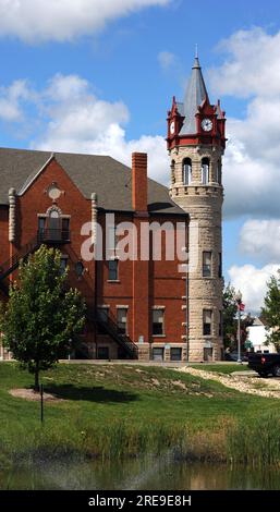 Seitenansicht von Stoughton, Wisconsin, Opernhaus und Rathaus. Der runde Turm beherbergt vier Uhren in Studentenwohnheimen mit viktorianischer Architektur. Stockfoto