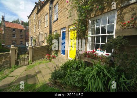 Robin Hood's Bay, Hinterstraße, farbenfrohe Türen, sonniger Ort, mit Blick auf den Eingang zu einer engen Wohngasse, Pfad. Alle Alleys sind zu Ende Stockfoto