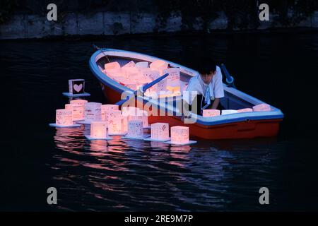 Tokio, Japan. 26. Juli 2023. Während des Toro Nagashi Festivals im Chidorigafuchi Moat in Tokio stellt ein Mitarbeiter Papierlaternen auf das Wasser. Toro Nagashi ist ein japanisches Flusslaternen-Festival, das im Sommer stattfindet, bei dem die Teilnehmer Laternen freisetzen, die Menschen repräsentieren, die gestorben sind, und ihre Geister durch das Schwimmen im Wasser in die andere Welt zurückgeschickt werden. Die Veranstaltung findet am 26. Und 27. Juli statt. (Kreditbild: © Rodrigo Reyes Marin/ZUMA Press Wire) NUR REDAKTIONELLE VERWENDUNG! Nicht für den kommerziellen GEBRAUCH! Stockfoto