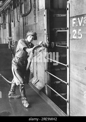 Horace Nicholl - Eine Mitarbeiterin, die ein Schnapsventil öffnet, um Bottiche in einem Gärraum einer Londoner Brauerei zu reinigen - 1914-1918 Stockfoto