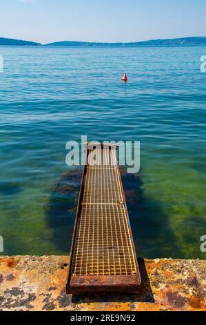 Eine verrostete alte Anlegestelle an der Adriaküste Kroatiens bei Kastel Kambelovac in Kastela. Spätwohnling Stockfoto