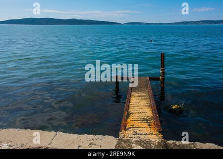 Eine verrostete alte Anlegestelle an der Adriaküste Kroatiens bei Kastel Kambelovac in Kastela. Spätwohnling Stockfoto