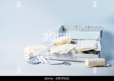 Erste-Hilfe-Kasten in einem Kasten für das Auto und als Hausmedizin Brust mit Verbänden, Pflastern, Pillen und Scheren, Gesundheit und medizinisches Konzept, hellblauer Rücken Stockfoto