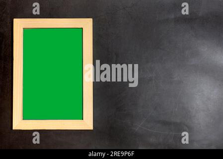Holzbilderrahmen innen mit grünem Bildschirm auf dunklem Hintergrund. Kopierbereich für Text und Bilder. Stockfoto