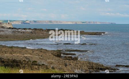 Porthcawl, Bridgend, Wales; Küstenlandschaft bei Ebbe mit einem felsigen Strand und einem launischen, wolkigen Himmel. Stockfoto