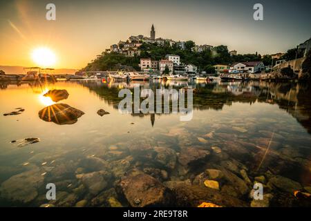 Der historische Ort vrbnik in Croatsia auf der Insel Krk. Bei Sonnenaufgang direkt am Meer, dem Hafen, spiegelt sich die Stadt wider Stockfoto