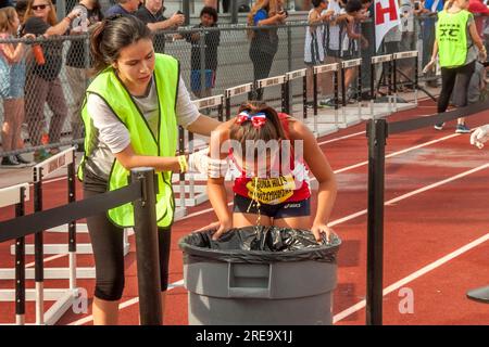 9. September 2017: Mit Hilfe eines jungen Freiwilligen erbricht eine erschöpfte und kranke Sportlerin in einem Fass, nachdem sie die Ziellinie eines einladenden Highschool-Skilanglaufens in Laguna Hills, Kalifornien, überquert hat. (Kreditbild: © Spencer Grant/ZUMA Press Wire) NUR REDAKTIONELLE VERWENDUNG! Nicht für den kommerziellen GEBRAUCH! Stockfoto