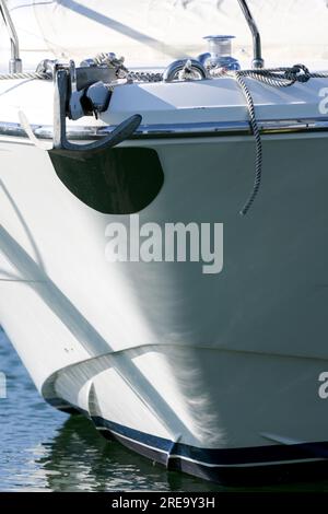 Teilansicht des vorderen Bugs einer weißen Freizeitaryacht mit Metallanker als Konzept für die Verankerung der Zuverlässigkeit im Hafen Stockfoto