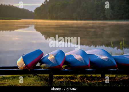 Kajaks am Seeufer, Sonnenaufgang Stockfoto