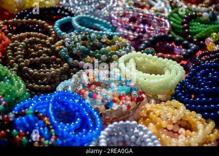 Frauenschmuck, kleines Unternehmen. Handgefertigte Armbänder aus mehrfarbigen Perlen auf der Theke eines Straßenmarkts, Vollformat. Nahaufnahme. Selektiver FOC Stockfoto