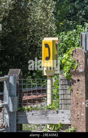 Gelbes Signal Post Telefon neben dem Bahnübergang. Dies ist auf der Imrys China Clay Route durch Lostwithiel, Cornwall. Stockfoto