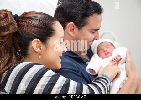 Junge Mutter und Vater mit ihrem neugeborenen Mädchen im Krankenhaus am Tag ihrer Geburt. Familienkonzept. Elternschaftskonzept Stockfoto