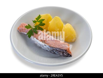 In Scheiben geschnittener gekochter Lachs mit Kartoffeln und Petersilie-Blättern in weißer Schale isoliert auf weißem Boden mit Schnittpfad im Preis inbegriffen Stockfoto