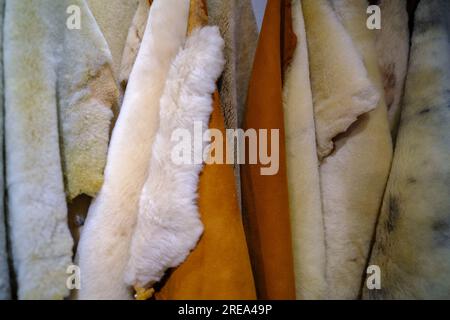 Weißer und brauner Wollhintergrund. Natürliche flauschige Schafwolle Hautstruktur. Echte Schafwolle, Nahaufnahme, selektiver Fokus. Hochwertige Kleidung für Stockfoto