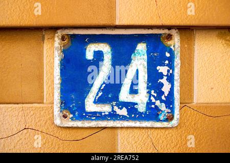 Nummer 24, vierundzwanzig, grausige blaue Platte auf Fliesenhintergrund. Stockfoto
