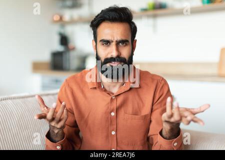 Porträt eines unzufriedenen Arabers, der drinnen in die Kamera schaut Stockfoto