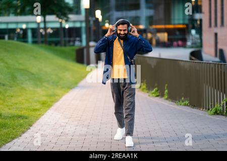 Ein Indianer Mit Kopfhörern, Der Im Freien „Walk With Favorite Music“ Spielt Stockfoto