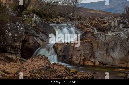 Seidiges Wasser, das langsam über die Felsen in Glencoe, Schottland, strömt Stockfoto