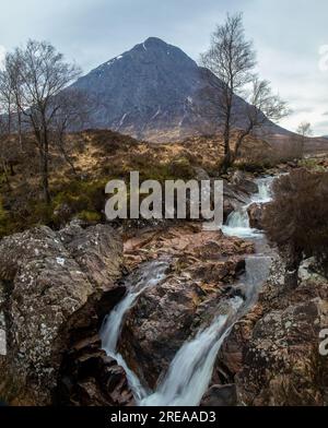 Stürmische Szene des Buachaille Etive Mor, Berg in Glencoe, Schottland, mit sanftem Wasserfall im Vordergrund Stockfoto