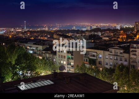 Nachtaufnahme und Blick auf die Straße, Bäume und Lichter der Stadt, Stockfoto