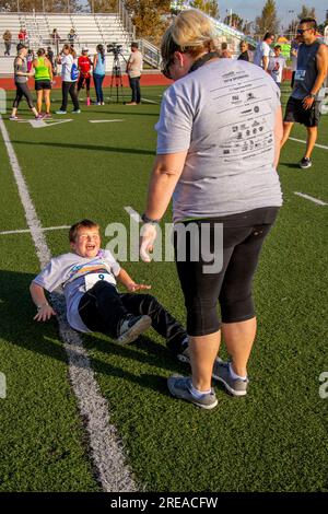 Costa Mesa, Kalifornien, USA. 23. September 2018. Während seine mutter zwangsläufig seine Zehen festhält, macht ein 8-jähriger Junge einige vorbereitende Sit-Ups, bevor er in einem lokalen Fußrennen in Costa Mesa, Kalifornien, läuft. (Kreditbild: © Spencer Grant/ZUMA Press Wire) NUR REDAKTIONELLE VERWENDUNG! Nicht für den kommerziellen GEBRAUCH! Stockfoto