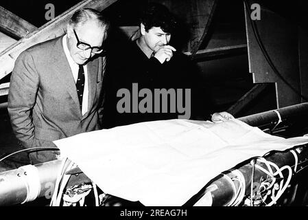 AJAXNETPHOTO. 25TH. MÄRZ 1975. PORTCHESTER, ENGLAND - YACHTSMAN CHAY BLYTH (GBR) (RECHTS) MIT SEINEM SPONSOR „UNION“ JACK HAYWARD, DER DIE BAUKOSTEN VON £120.000 FÜR BLYTHS NEUEN 80FT GLASS FIBRE TRIMARAN GREAT BRITAIN III ÜBERNIMMT, SCHAUEN SIE SICH DIE PLÄNE DER YACHT AUF DEM WICORMARINE YARD AN. ES WAR HAYWARDS ERSTER BESUCH, UM DIE NEUE YACHT IM BAU ZU SEHEN. FOTO : JONATHAN EASTLAND / AJAX REF: 232404 94 Stockfoto